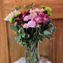 Pink and purple chrysanthemum bouquet in a clear glass vase