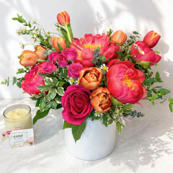 Bright mixed bouquet of pink and orange flowers in a white vase