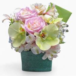 Compact pastel arrangement of pink roses, green orchids, and white alstroemeria in a teal cube vase