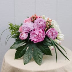 Pink peonies and white flowers arranged in a low bouquet