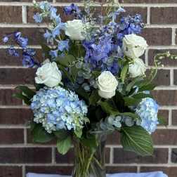 Blue and white floral arrangement in a glass vase