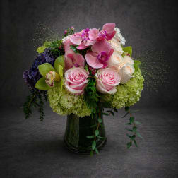Pink and white floral arrangement in a dark glass vase