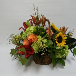 Basket arrangement with sunflowers, lilies, and roses