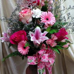 Pink and white mixed flower arrangement in a vase with a Mother's Day sign