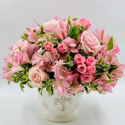Pink roses and alstroemeria arranged in a white vase