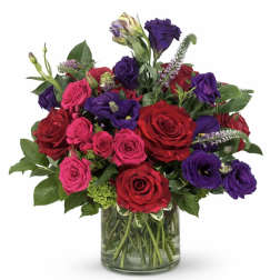 Bouquet of red, pink, and purple roses in a glass vase