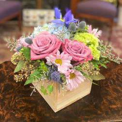 Pink roses and pastel mixed flowers arranged in a wooden box