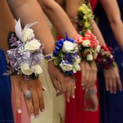 Bridesmaids wearing floral wrist corsages in white, blue, pink, and purple