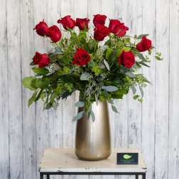 Red roses arranged in a tall metallic vase