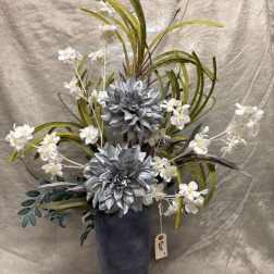 Tall floral arrangement with silver flowers and white blossoms in a dark vase