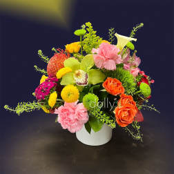 Colorful mixed flower arrangement in a white vase with pink, orange, yellow, and green blooms