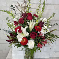 Red and white mixed flower arrangement in a glass vase