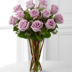 Lavender roses arranged in a clear glass vase