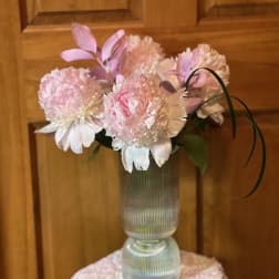 Pink and white floral arrangement in a ribbed glass vase