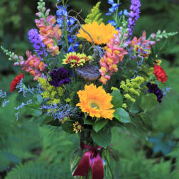 Mixed bouquet in a glass vase with bright yellow and purple flowers