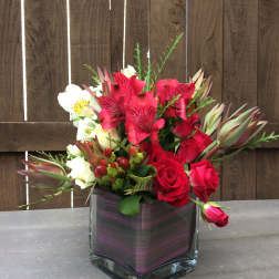 Red roses and white alstroemeria in a square glass vase