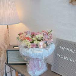 Pastel bouquet of roses and alstroemeria wrapped in white tulle