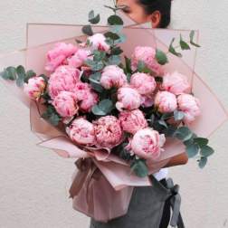 Pink peony bouquet wrapped in blush paper with eucalyptus