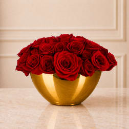 Red roses arranged in a gold bowl vase