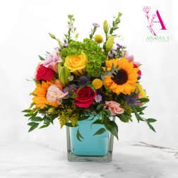 Colorful bouquet in a square glass vase with roses and sunflowers