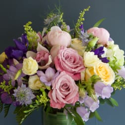 Bouquet of pink, yellow, and purple flowers in a glass vase