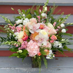 Mixed bouquet of pink, white, and peach flowers with orchids and roses