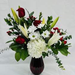 Red roses and white lilies with daisies in a dark vase