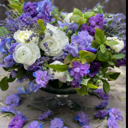 Purple and white floral arrangement in a dark vase