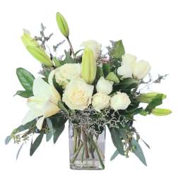 White roses and lilies in a clear glass vase