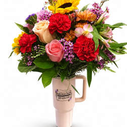 Mixed bouquet in a pink handled vase with sunflowers, roses, and carnations