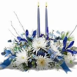 Blue and white floral centerpiece with two tall candles