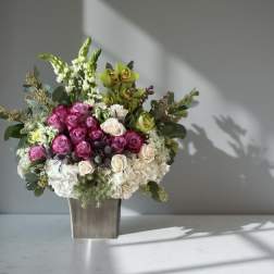 Bouquet of pink and white roses in a square vase