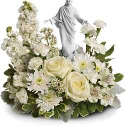 White floral arrangement with a small statue of Jesus at the center