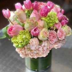 Pink tulips and roses arranged in a glass vase