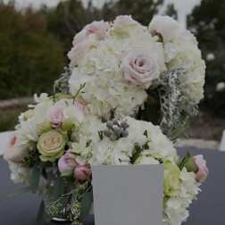 White and blush floral arrangements with roses and hydrangeas in a vase