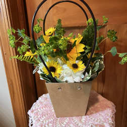 Sunflower and white hydrangea arrangement in a brown handled basket
