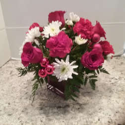 Pink and white flower arrangement in a dark vase