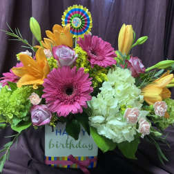 Colorful birthday flower arrangement in a box with gerberas, lilies, roses, and hydrangeas