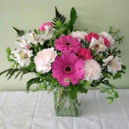 Pink gerberas and white alstroemeria in a clear glass vase