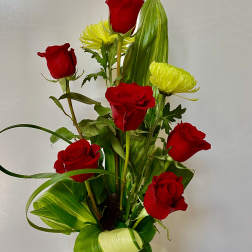 Red roses and yellow chrysanthemums in a glass vase