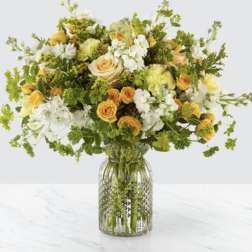 Yellow and white mixed flower bouquet in a glass vase