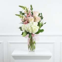 Bouquet of pale pink roses and white hydrangeas in a clear glass vase
