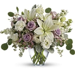 Lavender roses and white lilies in a clear glass vase