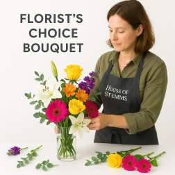 Florist arranging a colorful bouquet in a clear glass vase