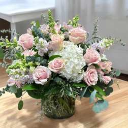 Pink roses and white hydrangea in a glass vase