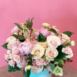 Pink and cream rose bouquet in a light blue vase