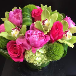 Pink roses and peonies with green orchids in a low arrangement