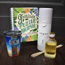 Gift set with a gratitude journal, tumbler, reed diffuser, and small bottle