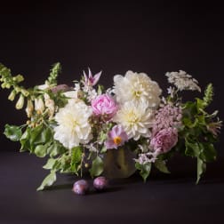 Low floral arrangement with white and pink blooms in a vase