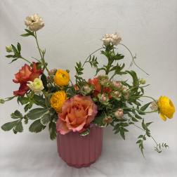 Mixed bouquet of roses and ranunculus in a pink vase
